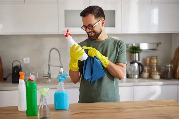 Profesional de limpieza preparando productos y útiles antes de comenzar el trabajo